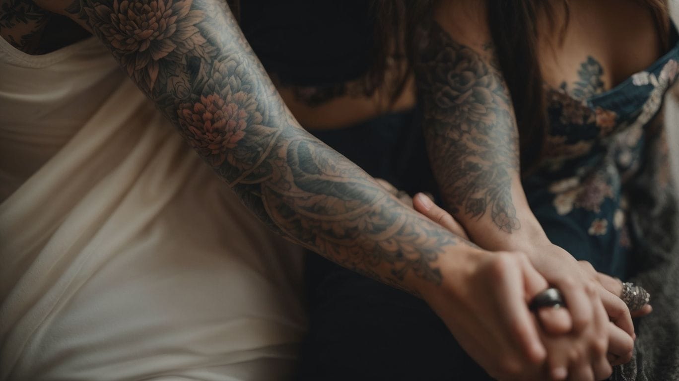 Two women holding hands, their interlocked arms proudly displaying tattoos that represent their bond as family.